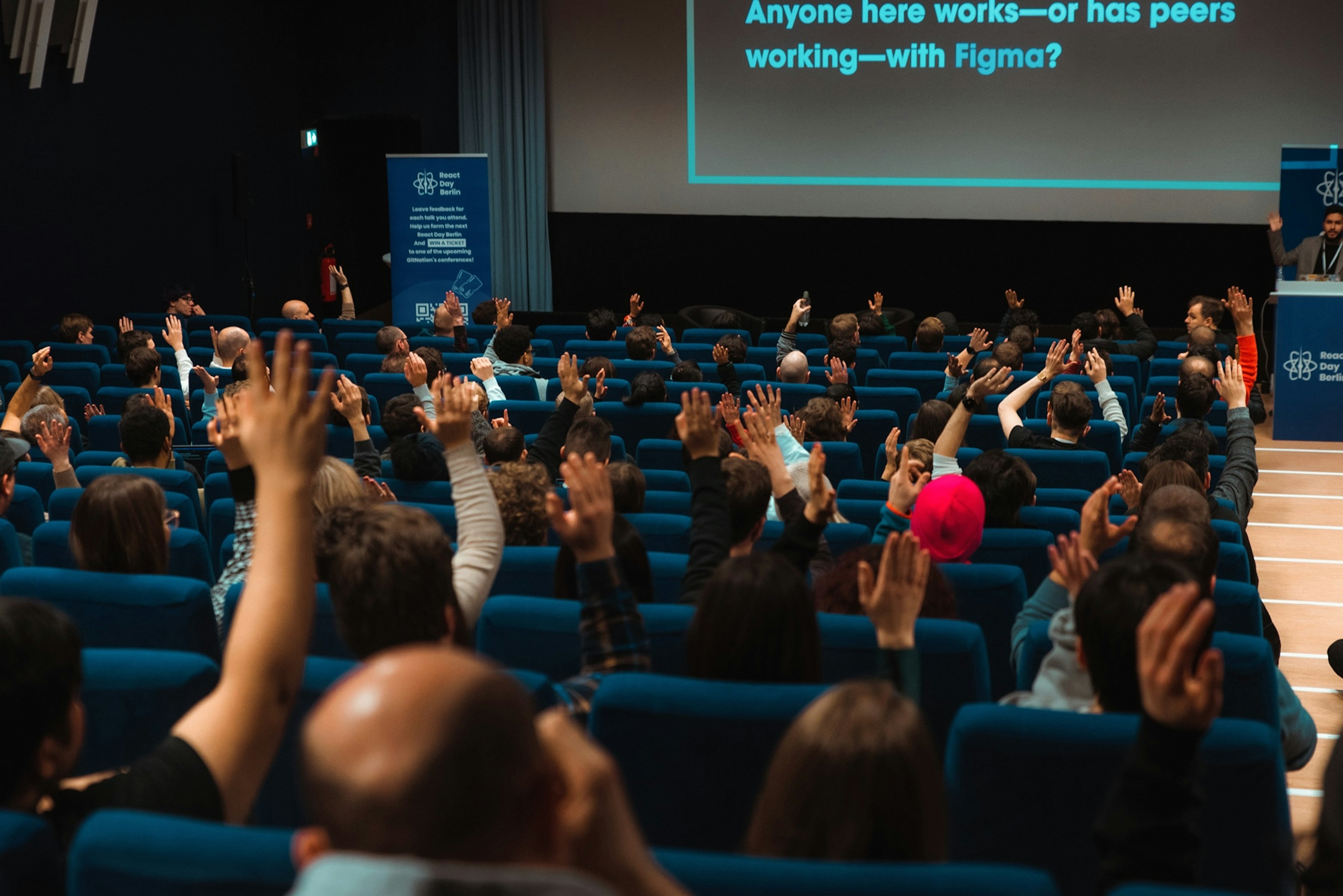 Audience raising hands at React Day Berlin 2022
